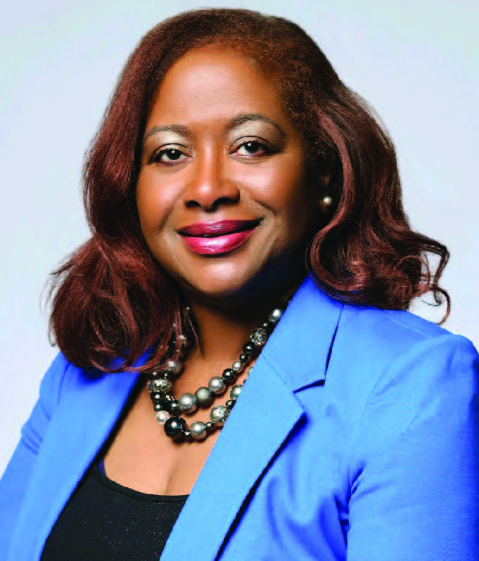 a photo of Billie Scruse, executive director an african american women smiling and wearing a blue jacket over a black shirt